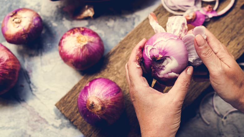 Person peeling onion 