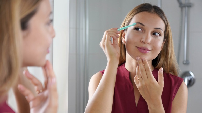 Woman shaving her face