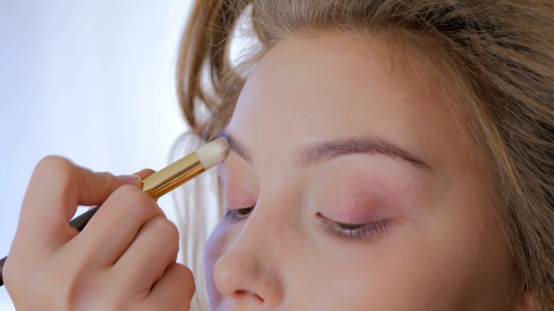 makeup artist applying eyeshadow primer 
