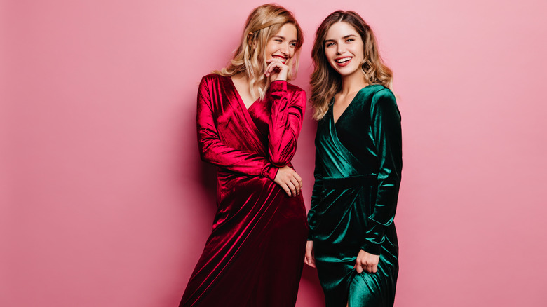 Two women wearing velvet dresses