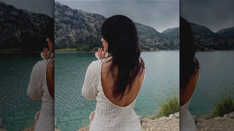 woman standing on seashore with witchy brunette hair