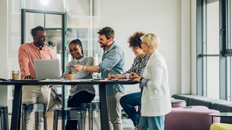 coworkers gathered in front of laptop