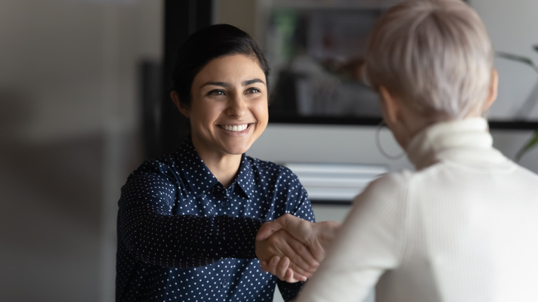 female employee shaking hands with boss