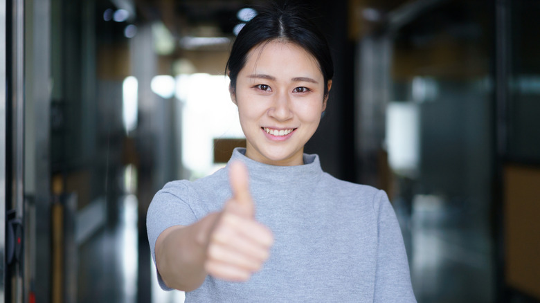 A woman giving a thumbs up.