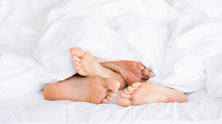 pairs of feet in bed