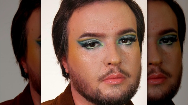 Man with yellow blush and green eyeshadow