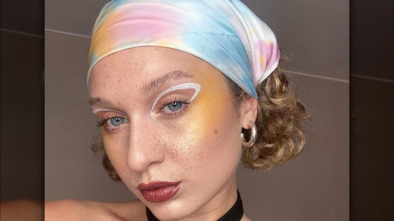 Woman with yellow blush and white eyeliner