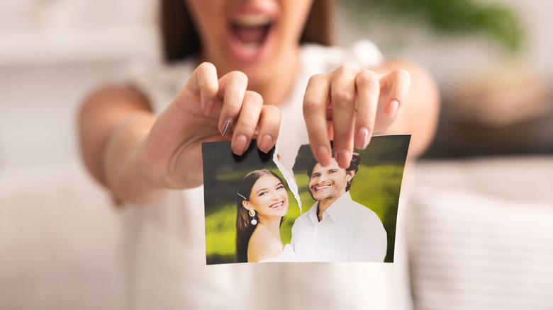 Woman tearing photo of relationship