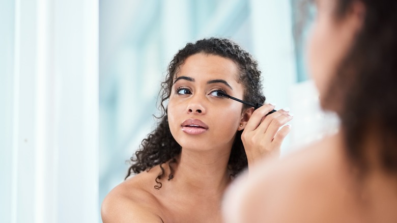 Women applying makeup in the mirror