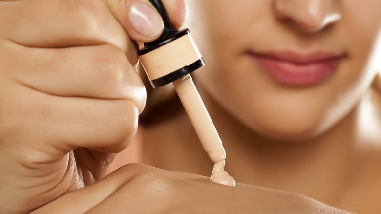 woman applying foundation on hand