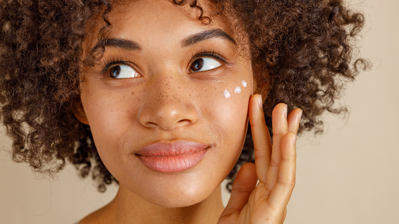 Woman with dots of product on cheek