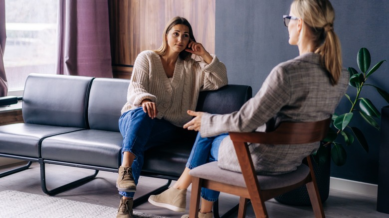 Two women engage in serious discussion in living room