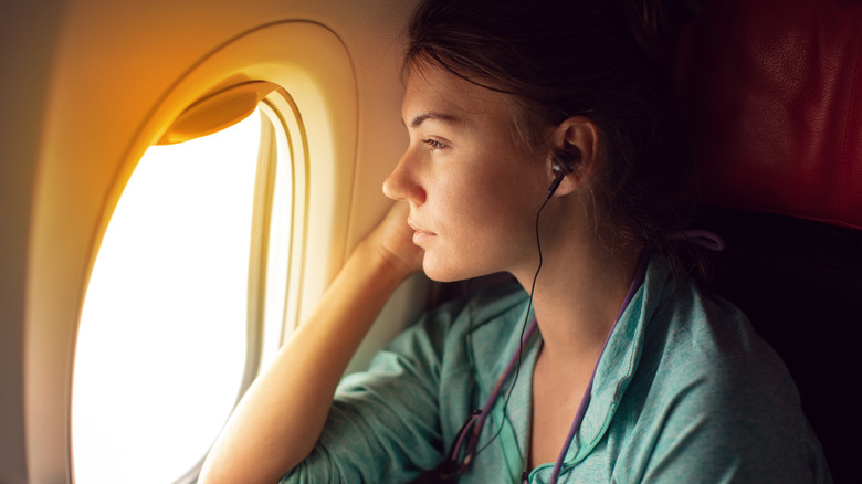 woman look out window airplane