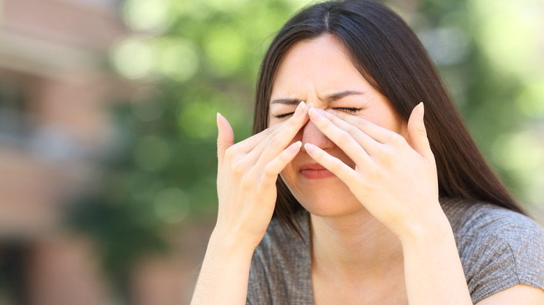 woman rubbing her eyes