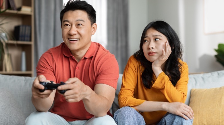 Woman watching man play games