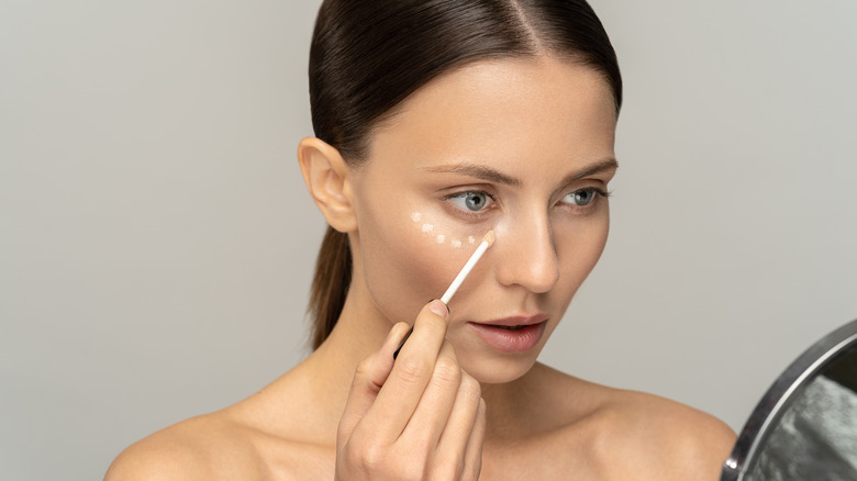 woman applying concealer