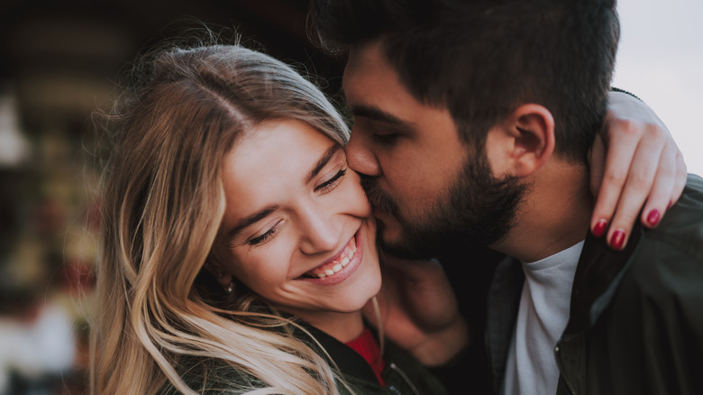 Bearded man kissing partner's cheek