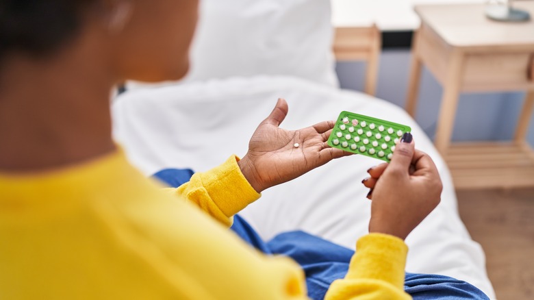 Woman holds birth control pills