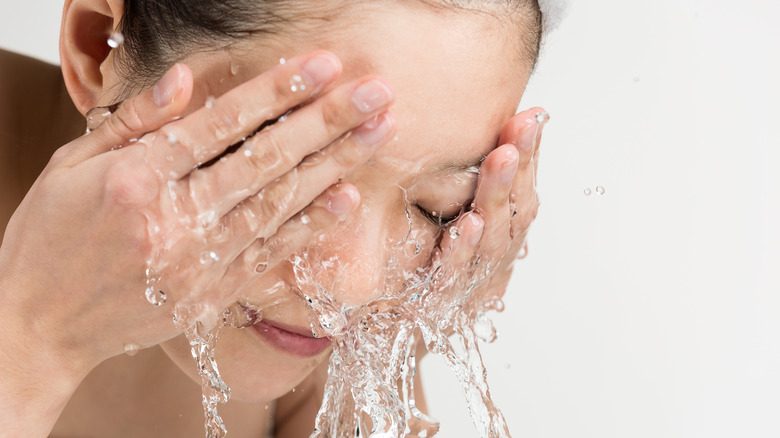 Woman splashing water on face