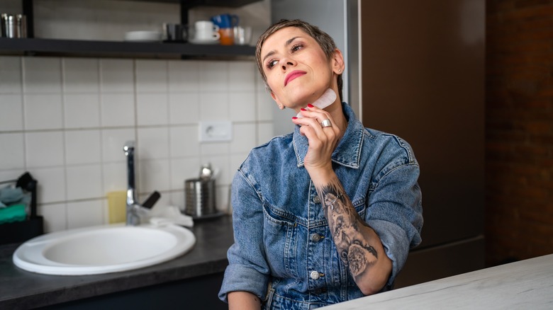 woman using gua sha on neck