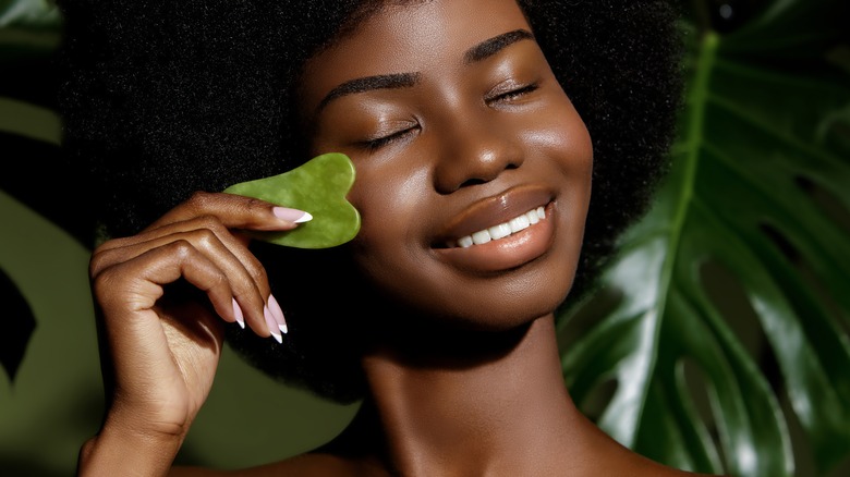 woman using gua sha on face