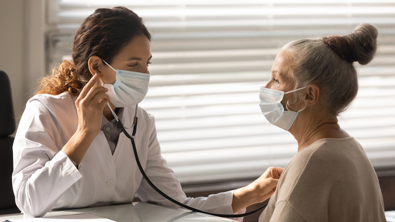 Doctor checks patient's heart