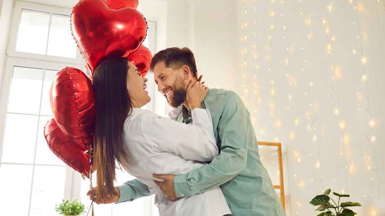 man giving baloons to woman