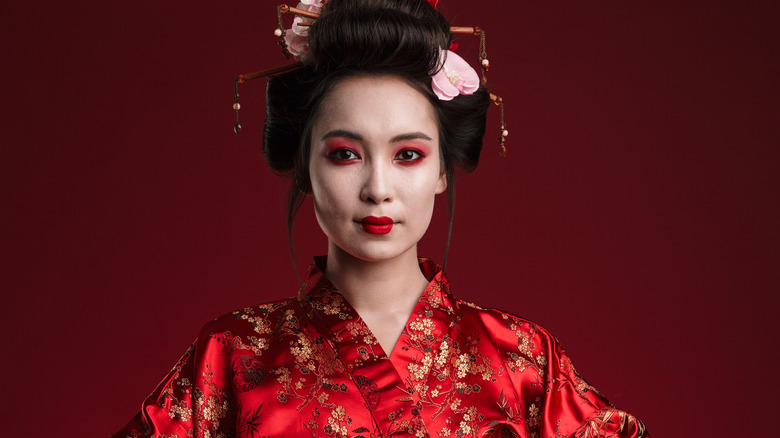 Asian women poses in traditional Geisha attire