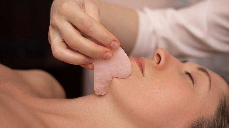 Gua sha being used on jaw