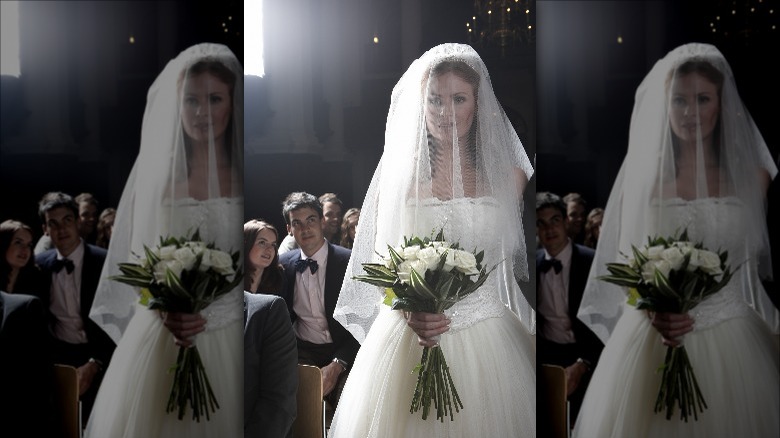 Bride wearing fingertip-length veil 