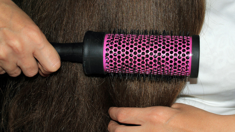 Brushing hair with metal brush