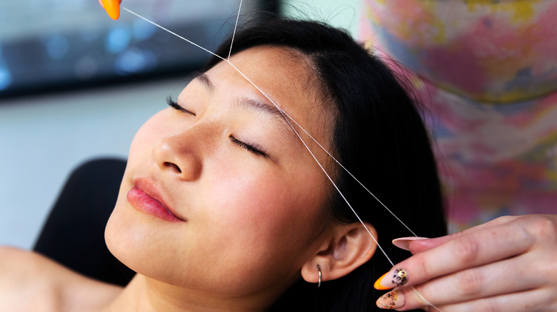 woman getting eyebrows threaded