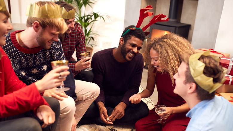 Partygoers laughing while wearing paper crowns