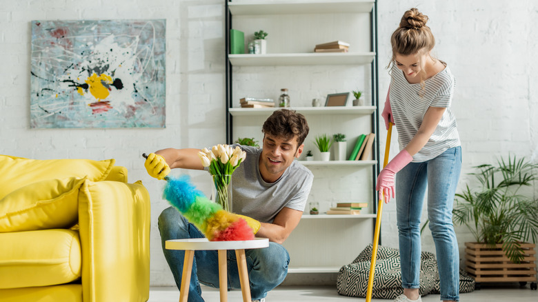 Two friends cleaning apartment together