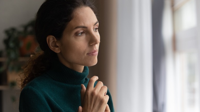 anxious woman looking out window