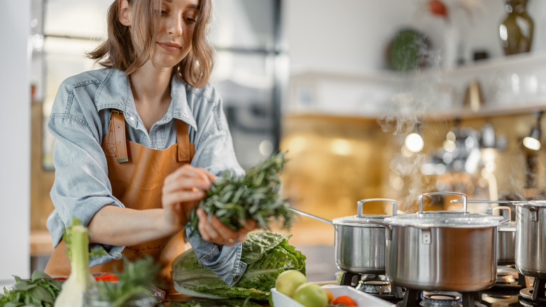 Woman prepares vegetables in kitchen