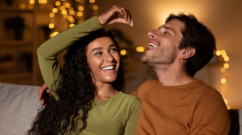 woman feeding man popcorn