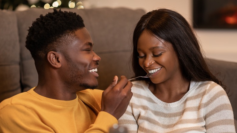 man feeding woman with fork