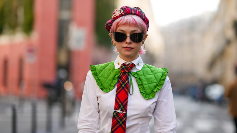 woman wearing plaid beret with matching plaid tie and white button up