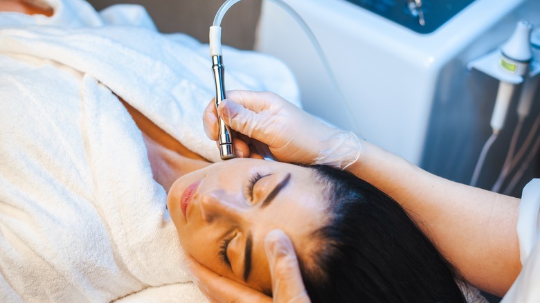 beautician performing microdermabrasion treatment