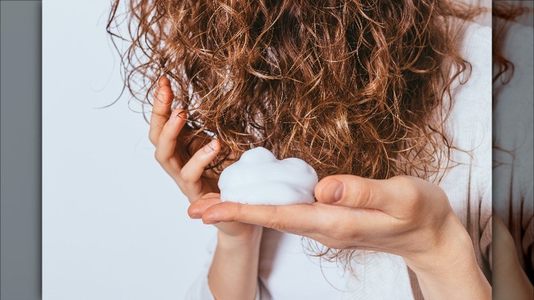 woman applying mousse to curly hair