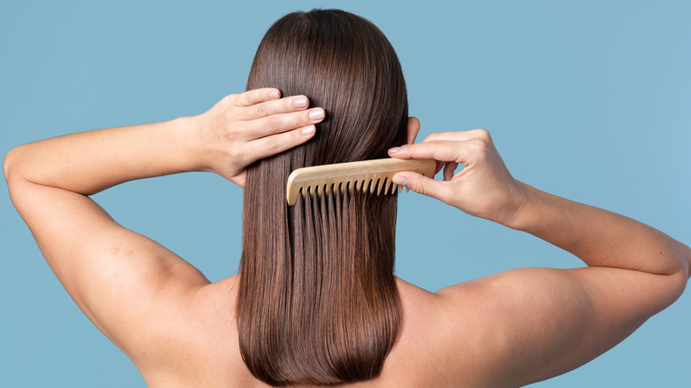 Woman combs her hair
