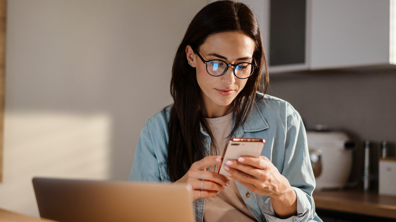 woman looking down at phone