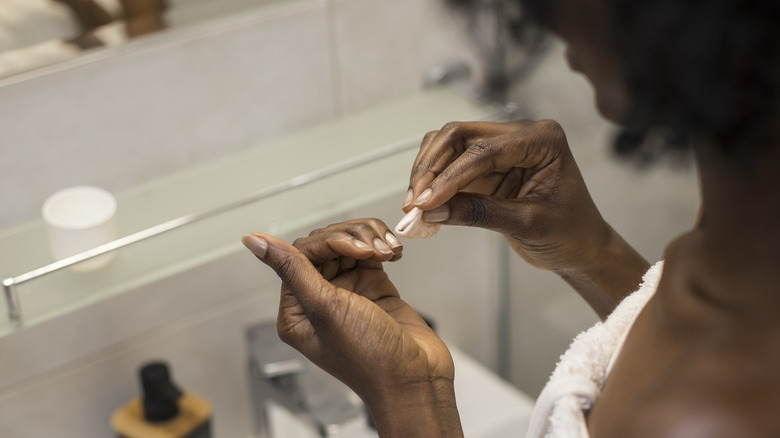 woman removing remnants of nails 