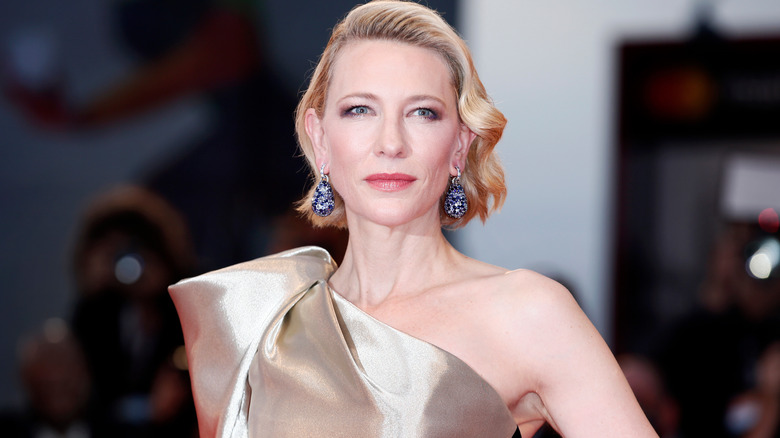 Cate Blanchett posing in gold one-shoulder gown