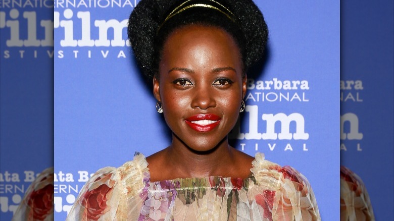 Lupita Nyong'o smiling in floral dress