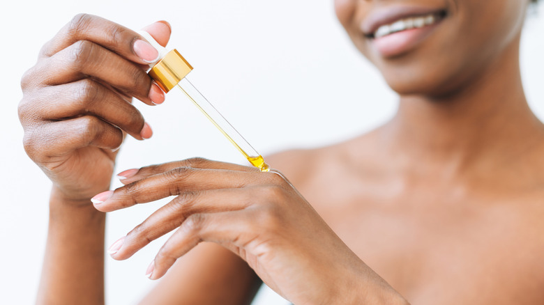 woman applying oil with dropper