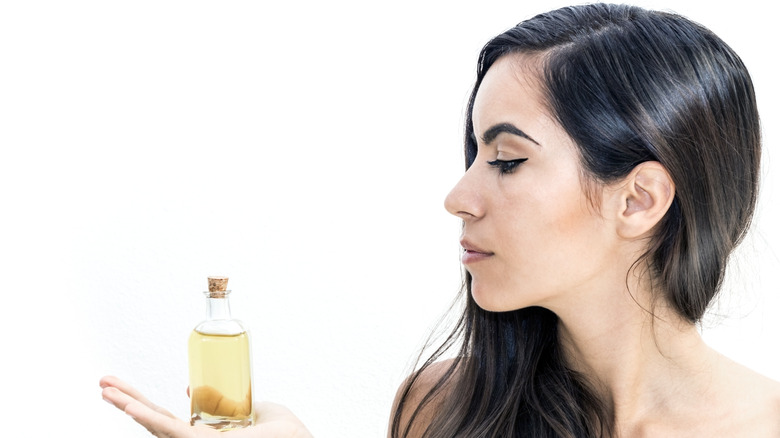 woman holding oil bottle