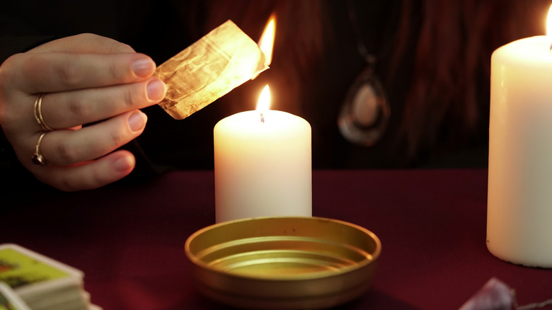Woman burning paper in ritual