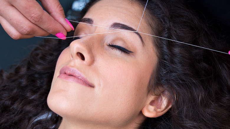 Woman getting eyebrows threaded